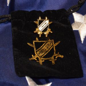 A Black pouch with a golden logo kpt on a blue cloth